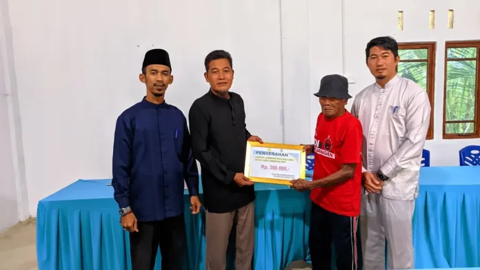 Kepala Desa didampingi Sekretaris Desa dan Ketua BPD secara simbolis menyerahkan bantuan kepada salah satu penerima BLT
