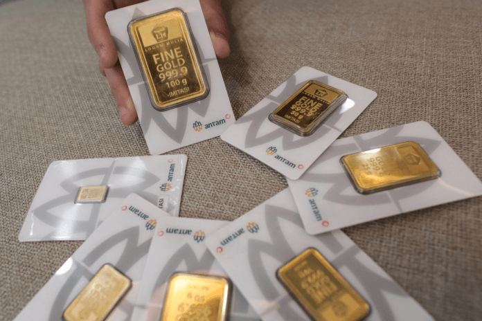 Ilustrasi emas batangan Antam dan grafik pergerakan harga