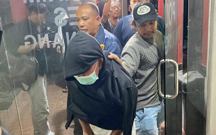 Tersangka mutilasi Nasrun di Tanjungpinang dikawal ketat polisi saat keluar dari gedung Mapolresta dengan wajah tertutup kupluk dan masker.