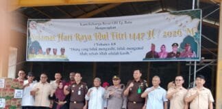 Wujud Toleransi di Bulan Puasa, GBI Kundur Salurkan 180 Paket Sembako kepada Masyarakat Sekelompok orang yang terdiri dari pengurus GBI Tanjung Batu, aparat kepolisian, kejaksaan, dan tokoh masyarakat berfoto bersama sambil mengepalkan tangan. Di belakang mereka terdapat spanduk ucapan Selamat Idul Fitri 1447 H dari GBI, dan di depan mereka tertumpuk puluhan karung beras serta kardus mi instan untuk bantuan sosial.