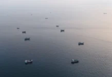 Dampak Konflik Selat Hormuz: Harga Minyak Dunia Melonjak, Bursa Saham Asia Bergejolak Deretan kapal pengangkut logistik maritim dunia yang lego jangkar di sekitar perairan utara semenanjung Musandam Oman dekat Selat Hormuz.