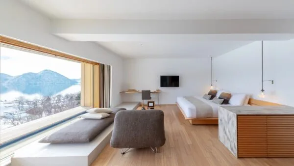 Desain arsitektur bagian dalam kamar mewah WE Hotel Toya Dusit Collection di Hokkaido dengan pemandangan langsung ke Danau Toya.