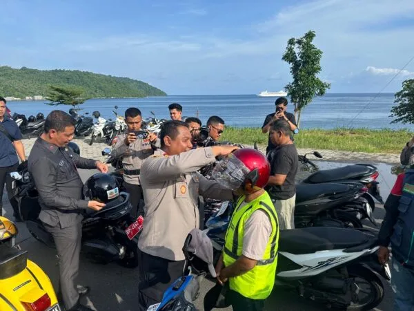Bupati Aneng bersama Kapolres Anambas AKBP I Gusti Ngurah Agung Budianaloka saat memasangkan helm gratis kepada perwakilan warga di Tarempa (Dok. Istimewa).