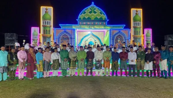 Wakil Bupati Karimun Rocky Bawole bersama panitia, dewan hakim, dan para juara MTQ Tingkat Desa Gemuruh 2026 foto bersama di depan panggung utama saat malam penutupan.