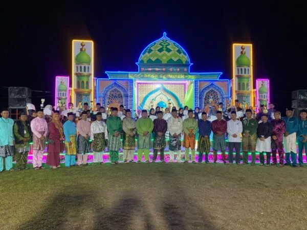 Wakil Bupati Karimun Rocky Bawole bersama panitia, dewan hakim, dan para juara MTQ Tingkat Desa Gemuruh 2026 foto bersama di depan panggung utama saat malam penutupan.