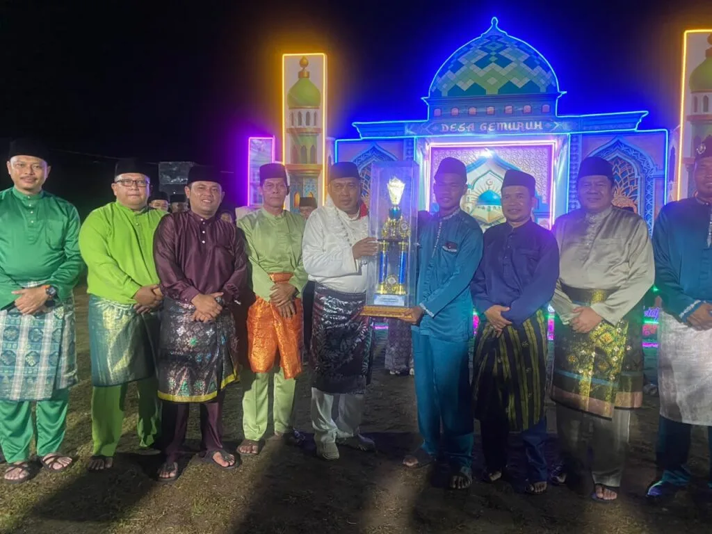 Wakil Bupati Karimun Rocky Bawole bersama panitia, dewan hakim, dan para juara MTQ Tingkat Desa Gemuruh 2026 foto bersama di depan panggung utama saat malam penutupan.