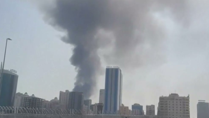 Personel penyelamat dan penanggulangan sipil Bahrain memeriksa puing bangunan di Muharraq yang rusak akibat serangan drone Iran.