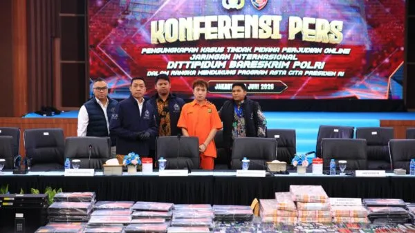 Konferensi pers Bareskrim Polri memperlihatkan buronan Interpol Beijing Zheng Rongjing berbaju tahanan oranye beserta barang bukti kejahatan judi dan scam online.