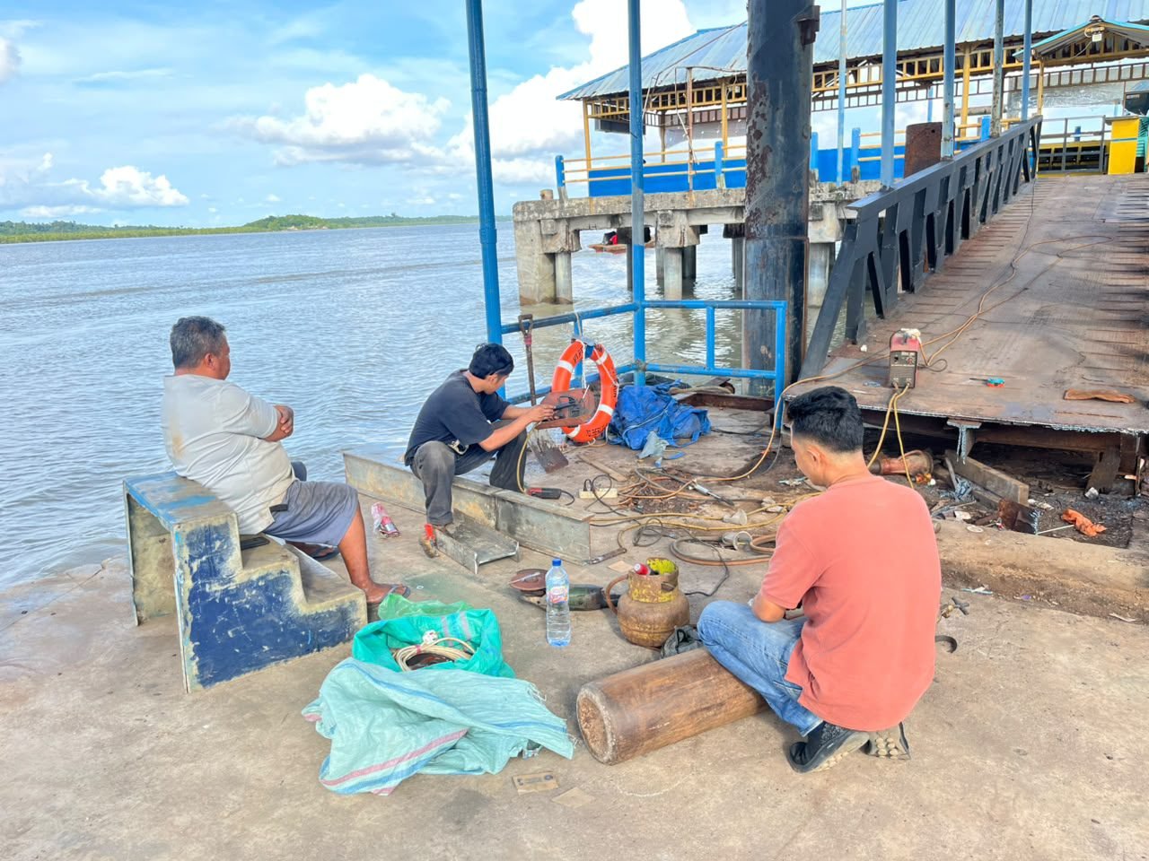 Suasana sejumlah tukang saat memperbaiki roda rolling jembatan pelabuhan apung Urung di Kundur Utara.
