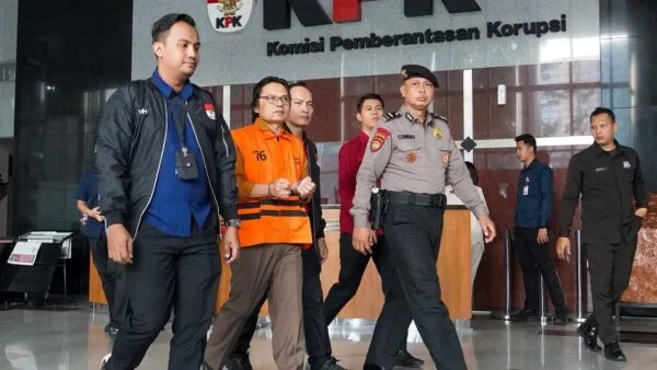 Tersangka korupsi MC mengenakan rompi tahanan orange KPK dengan kawalan petugas di Gedung Merah Putih Jakarta.