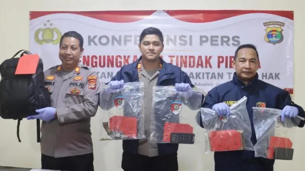 Kapolsek KSKP Bakauheni AKP Fransiskus Yepta Terang Ginting saat menunjukkan barang bukti senpi rakitan jenis revolver dan amunisi aktif.