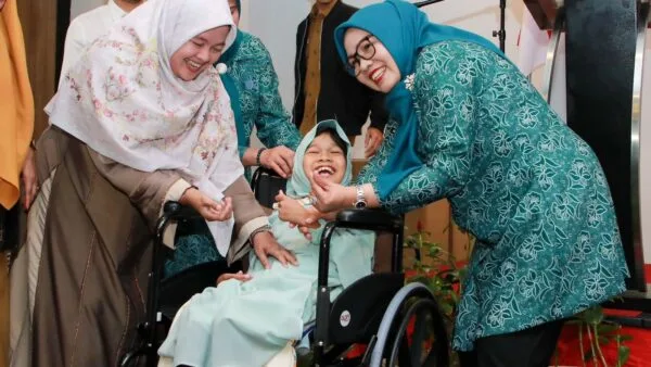 Ketua TP-PKK Batam Erlita Amsakar berinteraksi hangat saat menyerahkan bantuan kursi roda kepada penyandang disabilitas.