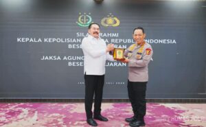 Kapolri Jenderal Listyo Sigit Prabowo bersalaman erat dengan Jaksa Agung ST Burhanuddin di Gedung Kejaksaan Agung.