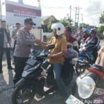 Jajaran Polsek Kundur membagikan bendera Merah Putih gratis kepada masyarakat pengendara jalan menyambut HUT Ke-81 RI