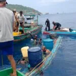 Tim penyelam gabungan dibantu warga nelayan berupaya mengevakuasi pompong yang tenggelam di perairan Pelabuhan Tarempa menggunakan drum plastik pelampung