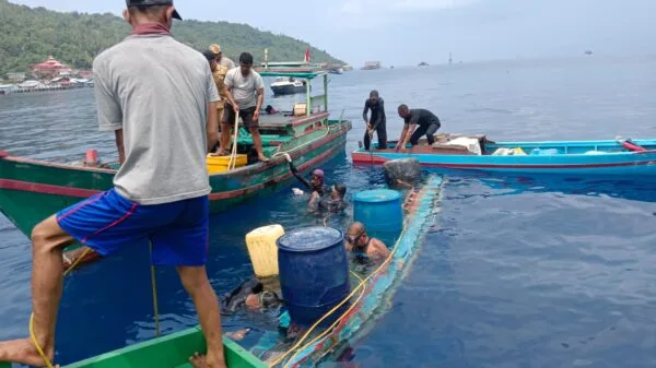 Tim penyelam gabungan dibantu warga nelayan berupaya mengevakuasi pompong yang tenggelam di perairan Pelabuhan Tarempa menggunakan drum plastik pelampung